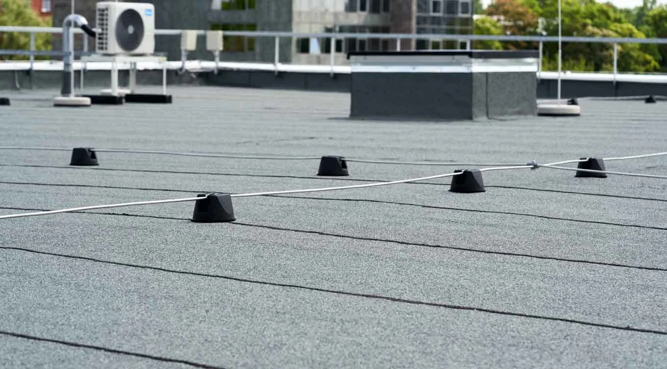 Low-slope roof with membrane seams, rooftop equipment and supported lines
