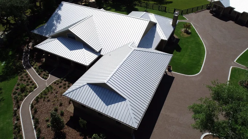 Aerial view of a white standing-seam metal roof with valleys and penetrations