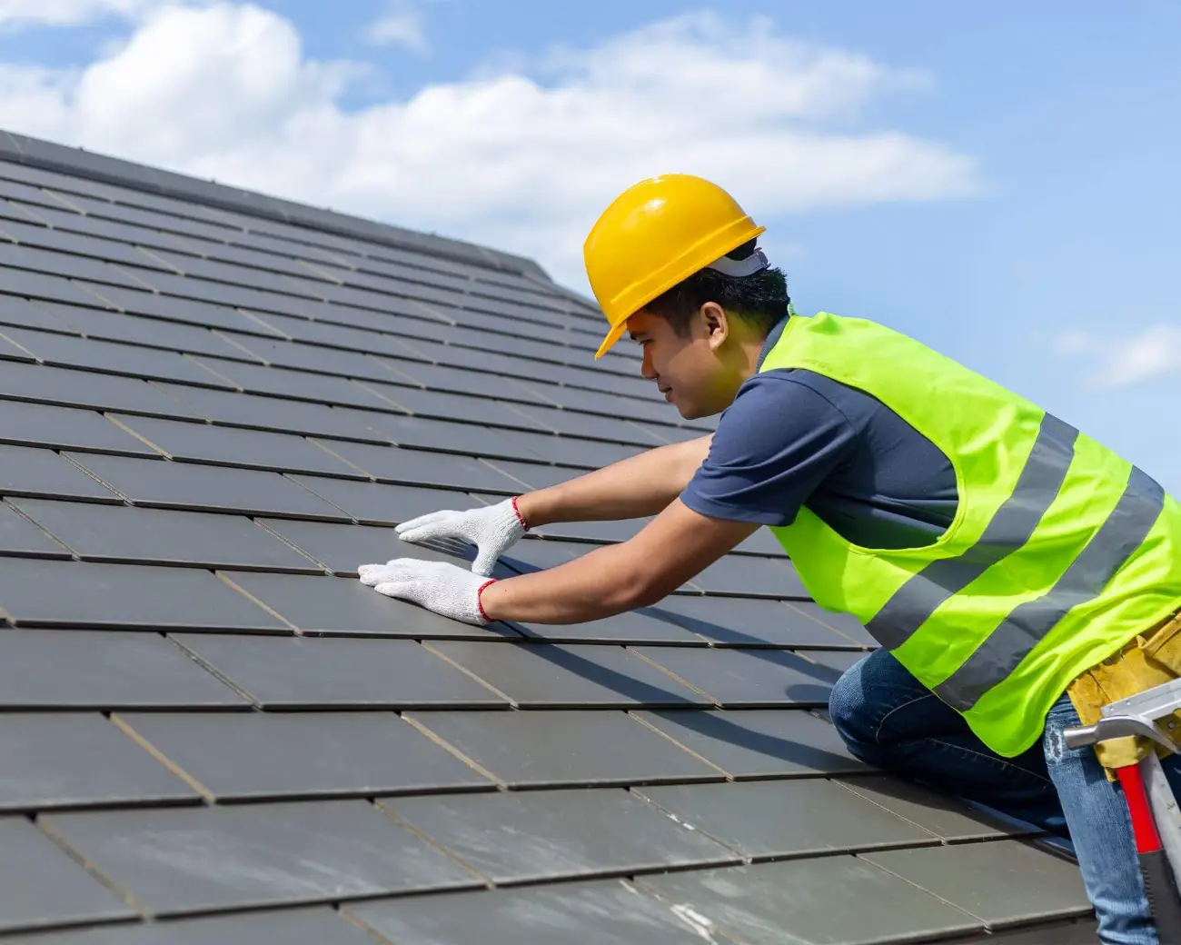Roofer installing flat concrete tile on a Palm Coast roof